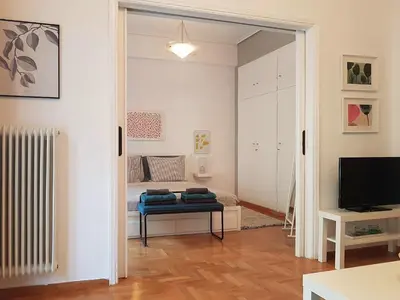 a room with a bed and a door leading to a bedroom at Colourful Apartment in the heart of Athens in Athens