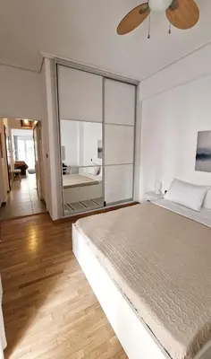 a bedroom with a large bed and a large window at Colourful Apartment in the heart of Athens in Athens