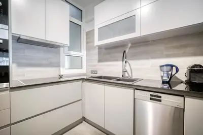 a white kitchen with a sink and a dishwasher at Bright Spacious Luxury Apartment in Prime Central Athens in Athens