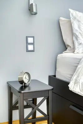 a table with a clock on it next to a bed at Bright Spacious Luxury Apartment in Prime Central Athens in Athens