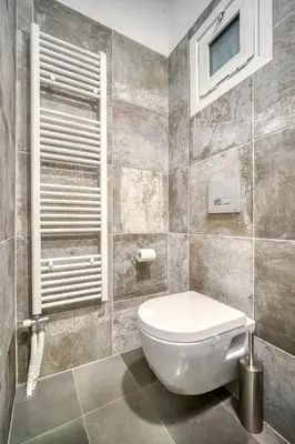 a bathroom with a white toilet and a window at Bright Spacious Luxury Apartment in Prime Central Athens in Athens