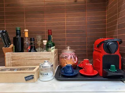 a counter with bottles of wine and a toaster at GRAND BLUE SUITE DI GIORGIO 10min from Piraeus port in Piraeus