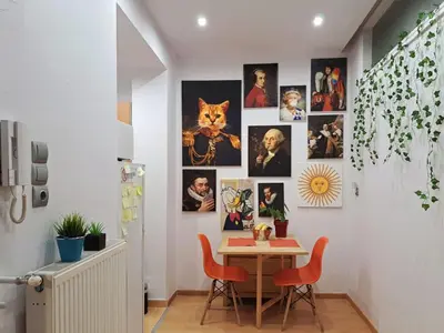 a dining room with a table and chairs and pictures on the wall at GRAND BLUE SUITE DI GIORGIO 10min from Piraeus port in Piraeus