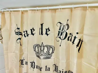 a shower curtain with a crown and writing on it at GRAND BLUE SUITE DI GIORGIO 10min from Piraeus port in Piraeus