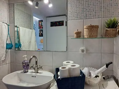 a bathroom with a sink and a mirror and towels at GRAND BLUE SUITE DI GIORGIO 10min from Piraeus port in Piraeus
