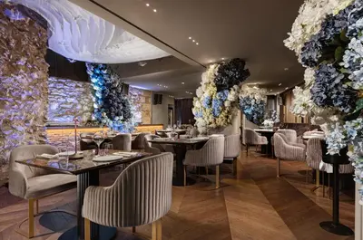 a restaurant with tables and chairs and flowers on the walls at Gatsby Athens in Athens