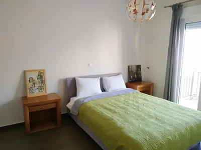 a bedroom with a bed with a green blanket at Pantazopoulou square apartment (central railway) in Athens