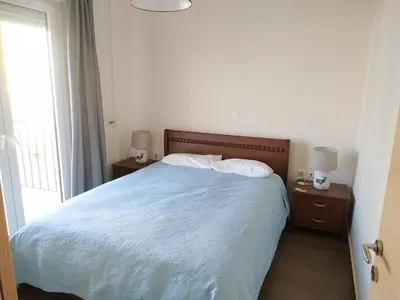 a bedroom with a bed and two nightstands and a window at Pantazopoulou square apartment (central railway) in Athens