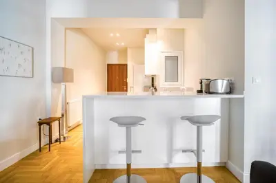 a kitchen with a counter and stools in a room at Lovely Sunlit Central Athens 2 Bedroom 2 Bathroom Condo in Athens