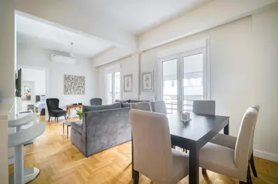 a living room with a couch and a table and chairs at Lovely Sunlit Central Athens 2 Bedroom 2 Bathroom Condo in Athens