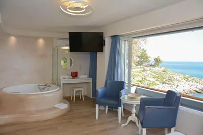 a room with a tub with a view of the ocean at Scorpios Sea Side Hotel in Piraeus