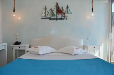 a white bed with two pillows on top of it at Scorpios Sea Side Hotel in Piraeus