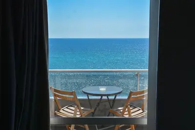 a view of the ocean from a balcony with a table and chairs at Scorpios Sea Side Hotel in Piraeus