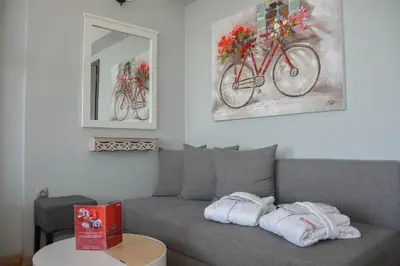 a living room with a couch with two bikes on the wall at Scorpios Sea Side Hotel in Piraeus