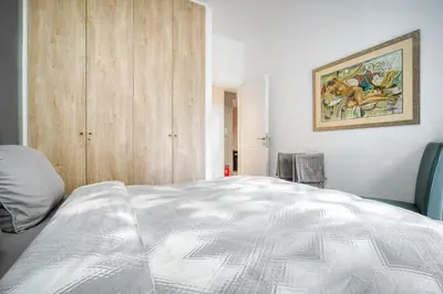 a bedroom with a bed and a painting on the wall at Delightful Stylish Two Bedroom Condo in Hip Area of Central Athens in Athens
