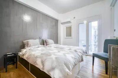 a bedroom with a large bed with a gray wall at Delightful Stylish Two Bedroom Condo in Hip Area of Central Athens in Athens
