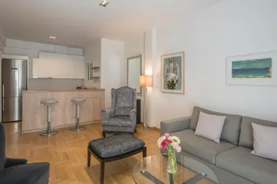 a living room with a couch and chairs and a kitchen at Delightful Stylish Two Bedroom Condo in Hip Area of Central Athens in Athens