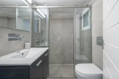 a bathroom with a shower and a toilet and a sink at Delightful Stylish Two Bedroom Condo in Hip Area of Central Athens in Athens