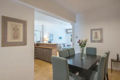 a dining room and living room with a table and chairs at Delightful Stylish Two Bedroom Condo in Hip Area of Central Athens in Athens