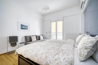 a white bedroom with a bed and a couch at Stunning Central 180m2 4 Bedroom 3 Bathroom, Sleeps 10 Guests in Athens