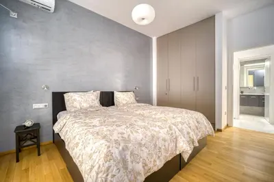 a bedroom with a bed and a gray wall at Stunning Central 180m2 4 Bedroom 3 Bathroom, Sleeps 10 Guests in Athens