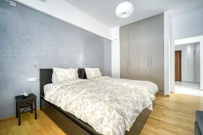 a bedroom with a large bed with a gray wall at Stunning Central 180m2 4 Bedroom 3 Bathroom, Sleeps 10 Guests in Athens