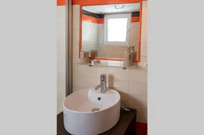 a bathroom with a white sink and a mirror at Vasilis Thissio Petralona 3d floor 55sqm in Athens