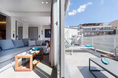 a living room with a couch and a table on a balcony at ATHENS PHOS Brand New Loft in Historical Athens Historical Center in Athens