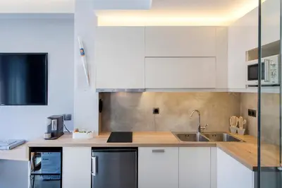 a kitchen with white cabinets and a sink at ATHENS PHOS Brand New Loft in Historical Athens Historical Center in Athens