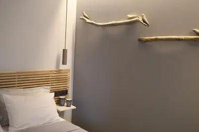 a bedroom with a bed and two logs on the wall at ATHENS PHOS Brand New Loft in Historical Athens Historical Center in Athens