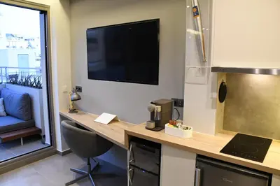 a kitchen with a desk with a television on the wall at ATHENS PHOS Brand New Loft in Historical Athens Historical Center in Athens