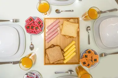 a table with a plate of bread and cheese and orange juice at Kleio by Heloni Apartments in Athens