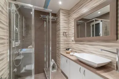 a bathroom with a glass shower and a sink at Kleio by Heloni Apartments in Athens