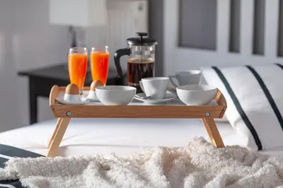 a tray with cups and drinks on a bed at Kleio by Heloni Apartments in Athens