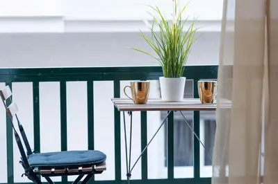a table with a chair and a plant on a balcony at Kleio by Heloni Apartments in Athens