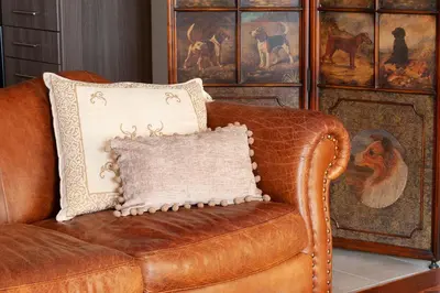 a brown leather couch with a pillow on it at Kleio by Heloni Apartments in Athens