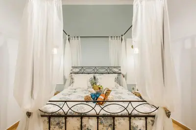 a bed with white curtains in a bedroom at Syntagma private sweet safe double rooms with shared bathroom in Athens