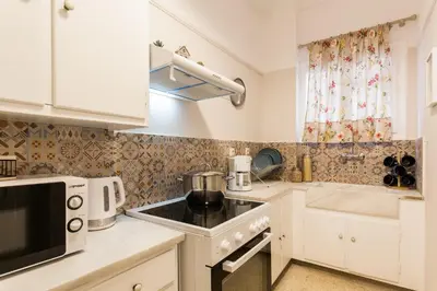 a kitchen with white cabinets and a stove top oven at Syntagma private sweet safe double rooms with shared bathroom in Athens