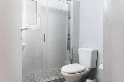 a white bathroom with a toilet and a shower at Syntagma private sweet safe double rooms with shared bathroom in Athens