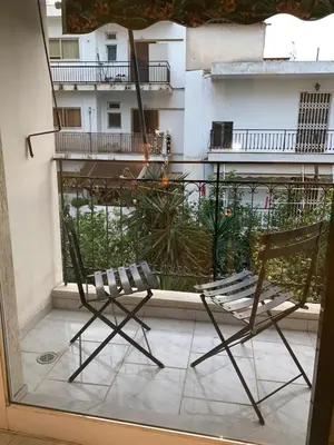 a pair of chairs sitting on a balcony at Treasure cosy flat in Athens