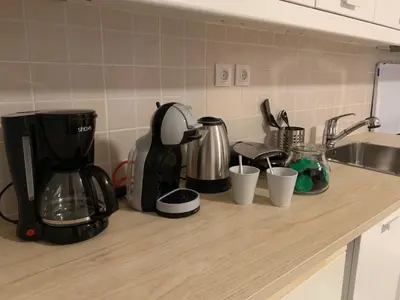 a kitchen counter with a coffee maker and cups on it at Treasure cosy flat in Athens
