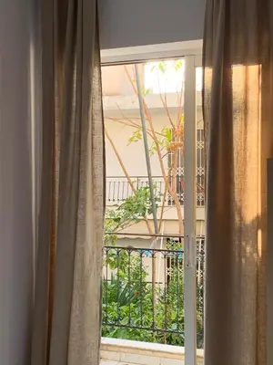 a window with a view of a balcony at Treasure cosy flat in Athens