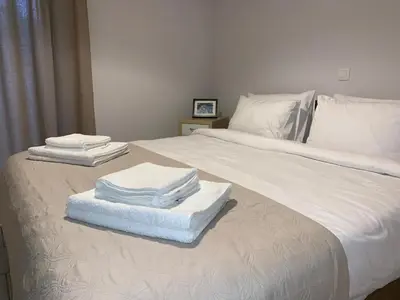 a white bed with towels stacked on top of it at Treasure cosy flat in Athens