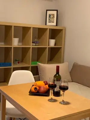 a table with two glasses of wine and fruit on it at Treasure cosy flat in Athens