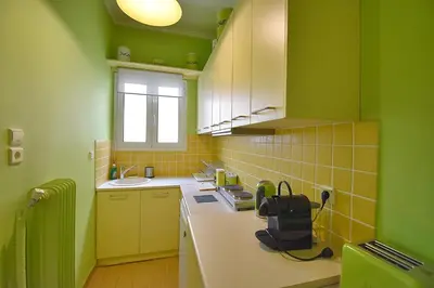 a green kitchen with a sink and a counter at Check Point - Plaka in Athens