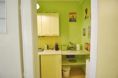 a small kitchen with green walls and white cabinets at Check Point - Plaka in Athens