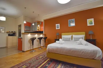 a bedroom with a large bed and a kitchen at Check Point - Down Town in Athens
