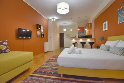 a bedroom with a large bed and a yellow couch at Check Point - Down Town in Athens