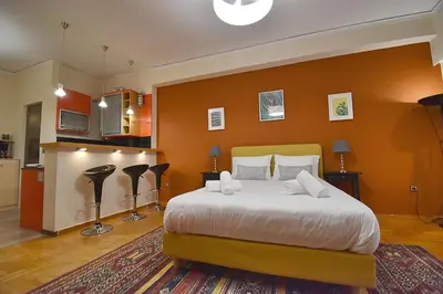 a bedroom with a large bed with orange walls at Check Point - Down Town in Athens
