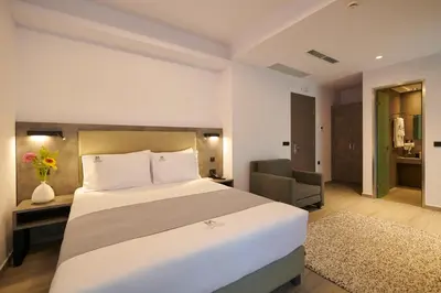 a hotel room with a bed and a chair at Meni Hotel & Apartments UNDER NEW MANAGEMENT in Athens